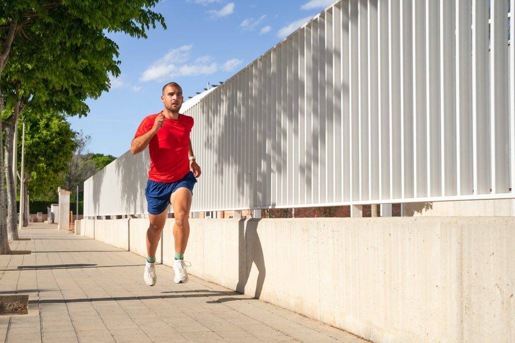 Young man running on the pavement.